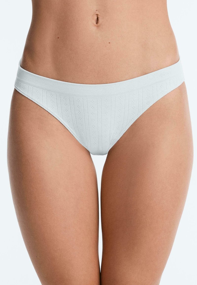 Gros plan d'une femme portant un sous-vêtement style bikini en tissu côtelé bleu clair avec un motif à rayures verticales texturées.