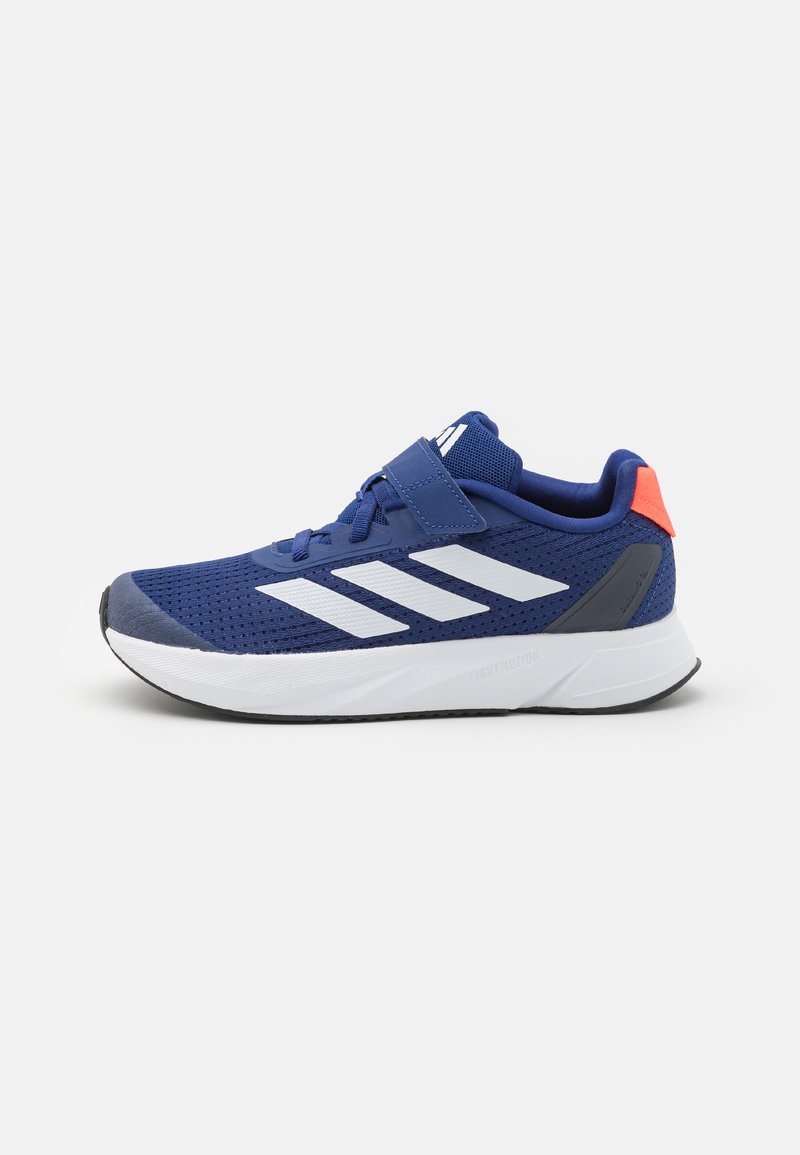 Zapatillas deportivas azules con parte superior de malla, que presentan tres franjas blancas, una correa de velcro y un acento naranja contrastante en el talón.
