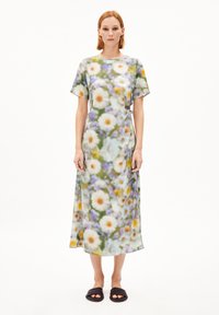Midi-Kleid mit Blumenmuster aus leichtem Stoff, mit kurzen Ärmeln, das Gänseblümchen und Akzente in Lila und Gelb auf grünem Hintergrund zeigt.
