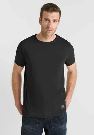 T-shirt corto nero con maniche a sbuffo, dotato di un collo rotondo e una texture liscia. Un piccolo etichetta del marchio è visibile in basso a sinistra.