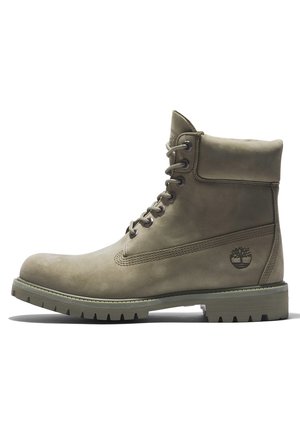 Stivaletto alla caviglia in pelle color taupe con lacci, collo imbottito, suola robusta e logo a rilievo a forma di albero sul lato.