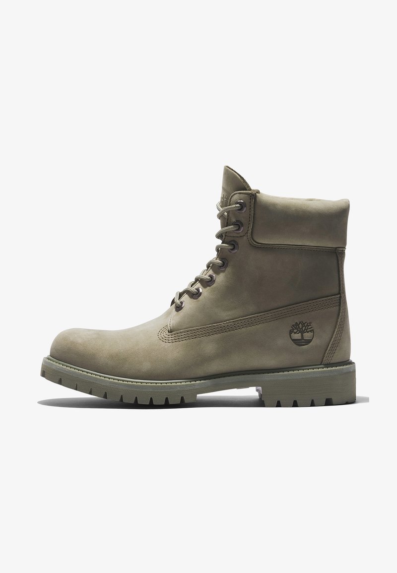 Bottine en cuir taupe à lacets, col matelassé, semelle robuste et logo en relief en forme d'arbre sur le côté.
