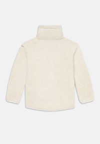 Kremowy polarowy sweter z wysokim kołnierzem, długimi rękawami i miękkim, fakturowanym wykończeniem. Posiada rękawy raglanowe oraz zaokrąglony dół.