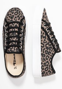 Plátěné tenisky s leopardím potiskem, černými detaily, bílou gumovou podrážkou a stříbrnými očky. Mají šněrovací design s etiketou uvnitř.