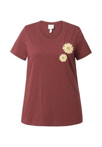 Camiseta de manga corta color marrón en tejido suave, con margaritas amarillas bordadas en el lado izquierdo. Cuello redondo, corte relajado.