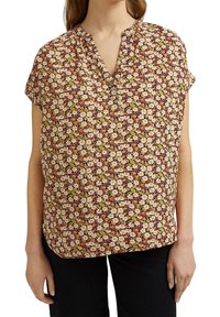 Blusa floreale con maniche corte, caratterizzata da uno sfondo bordeaux, fiori gialli chiari e verdi, e un colletto con mezze bottoni. Texture del tessuto morbida.