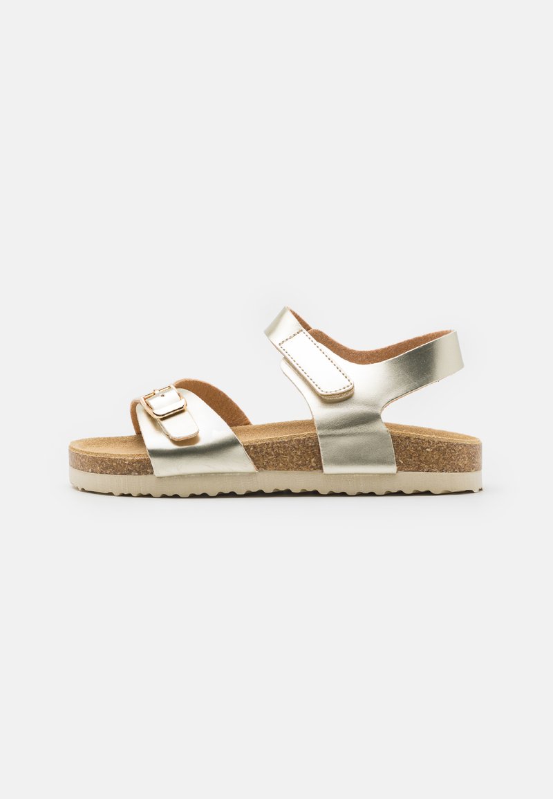 Goldene metallische Sandalen mit einem Korkfußbett, zwei verstellbaren Riemen und einer leichten Gummisohle. Sanfte Textur und minimalistisches Design.