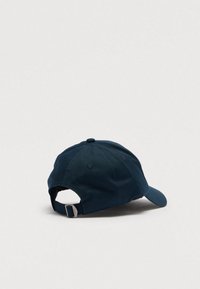 Tumesinine pesapallimüts reguleeritava rihma ja metallist pandlaga, esitletud lihtsal heledal hallil taustal.