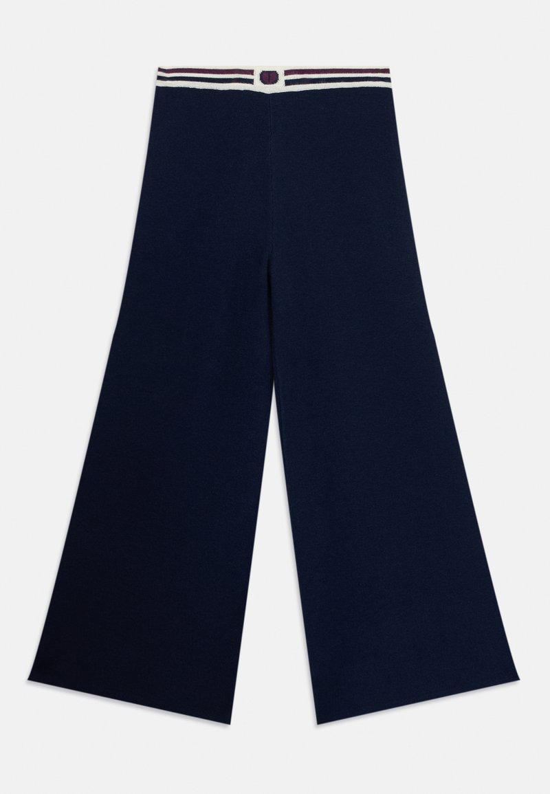 Breda byxor i marinblått i ett mjukt material, med en randig midja och en knappdetalj i mitten.