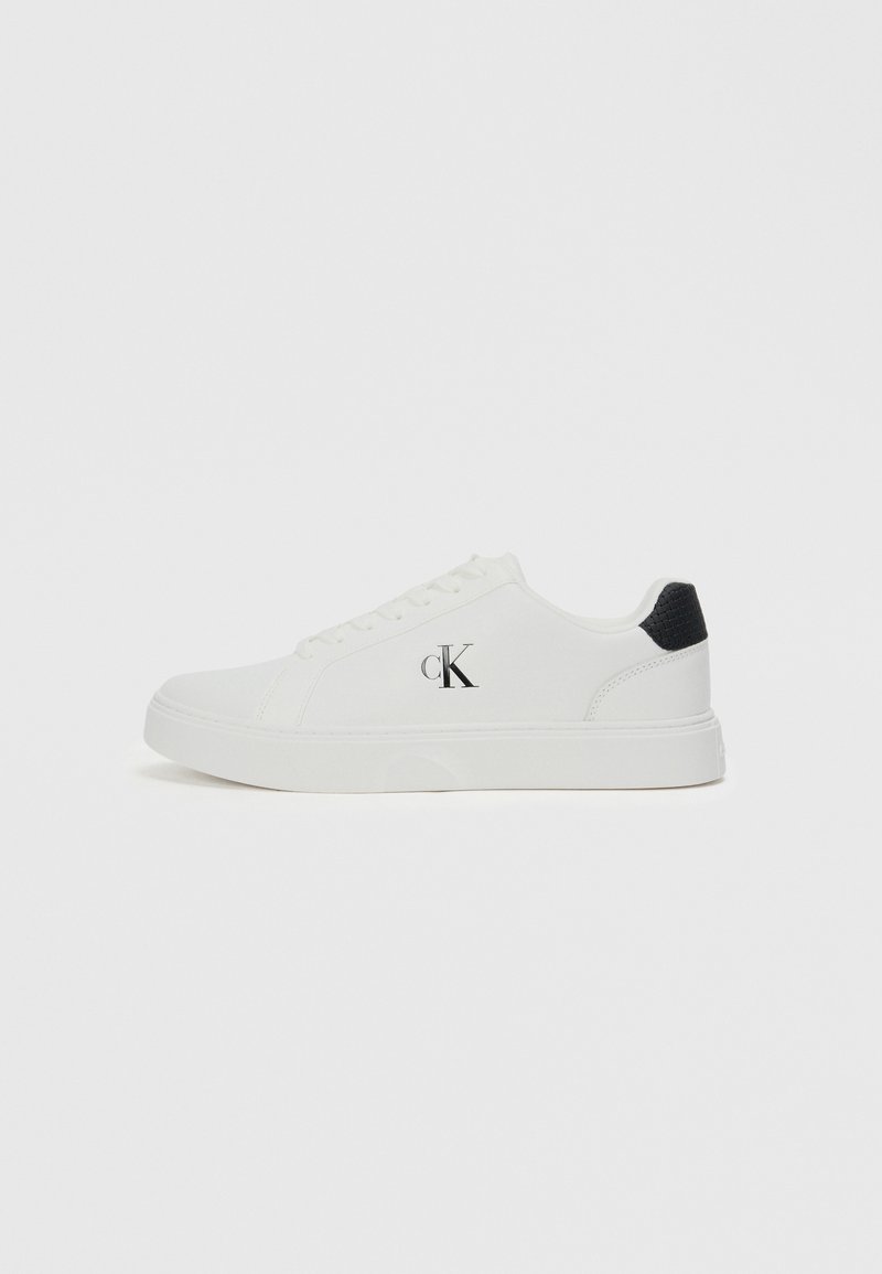 Białe sneakersy z gładkiej skórzanej cholewki, okrągłym noskiem, czarnym akcentem na pięcie oraz logo "CK" po boku. Posiadają system sznurowania i płaską podeszwę.