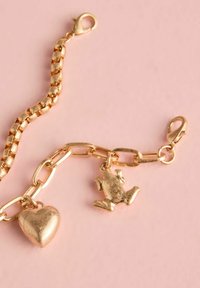 Guldtonet metalarmbånd med kædedesign, der har en charme i form af et hjerte og en frø. Glatte, blanke overflader og lukning med en lobsterklap.
