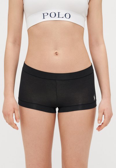 Sorte bomulds-shorts med en glat tekstur og et tætsiddende design. Har et diskret logo på siden og en kontrasterende talje.