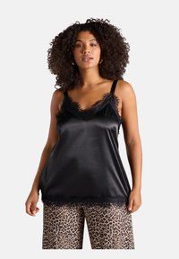 Top in satin nero con pizzo, dotato di spalline regolabili. Abbinato a pantaloni larghi con stampa leopardata. Texture complessivamente liscia.