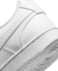 Białe sneakersy z teksturowaną skórzaną cholewką, zaokrąglonym noskiem, zakrzywionymi detalami szycia oraz wzorzystą gumową podeszwą z okrągłymi rowkami.