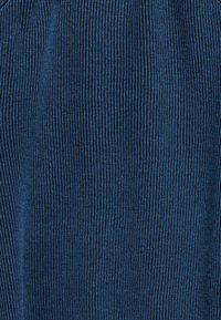 Donkerblauwe stof met een verticale ribbelstructuur, met een glad oppervlak en een gelijkmatig patroon. Geschikt voor kledingtoepassingen.