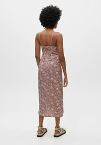 Midi-Kleid mit verstellbaren Spaghettiträgern, floralen Muster in Rosa und Creme, gerafften Details im Rücken und geradem Saum.