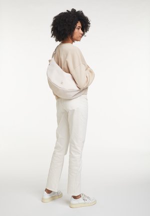 Borsa slouchy beige chiaro di forma curvata, realizzata in materiale morbido. Caratterizzata da un logo sobrio e una tracolla regolabile per una vestibilità personalizzata.