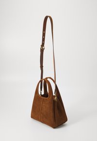 Borsa in suede marrone con doppi manici superiori e una tracolla in pelle staccabile, dotata di hardware dorato e un design angolare.