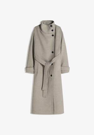 Hosszú szürke gyapjú kabát, magas gallérral, gombos záródással és övvel. Két oldalsó zsebbel rendelkezik, és a hüvelyek fel vannak görgetve a részletek fokozása érdekében.