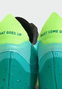 Aqua- och limefärgade sneakers med nätöverdel, med texten "WHAT GOES UP" och "MUST COME DOWN" på klacken samt fläckiga accenter.