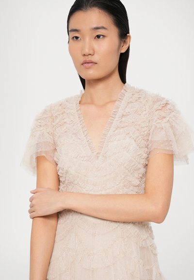 Ροζ φόρεμα με επίπεδο ρυάκι και ρίγες, V ντεκολτέ και διάφανες ρυτιδωτές μανίκες. Το ύφασμα φαίνεται ελαφρύ και ελαφρώς λαμπερό.