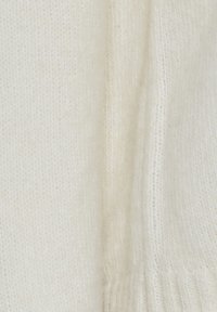 Pull crème avec un tricot doux et texturé. Présente un ourlet et des coutures côtelées, mettant en avant le motif de tricot détaillé et l'apparence chaleureuse dans l'ensemble.