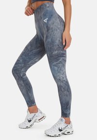 Hög midja leggings i ett blå-grått tie-dye mönster, med ett mjukt, stretchigt tyg och subtil detalj med logotyp på midjebandet.