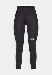 Leggings pretos de cintura alta feitos de tecido elástico. Apresentam um logótipo na coxa e um design liso e ajustado, sem padrões.