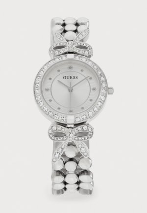 Sølvur med rund urskive, udsmykket med krystaller og en sløjfeaccent. Led-armbåndsdesign med polerede metalsfærer.