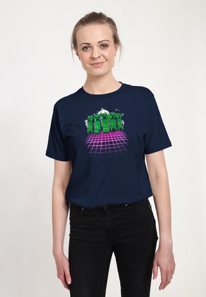Navy blue t-shirt featuring a graphic of green block figures on a pink grid background. Short sleeves, round neck, casual fit.