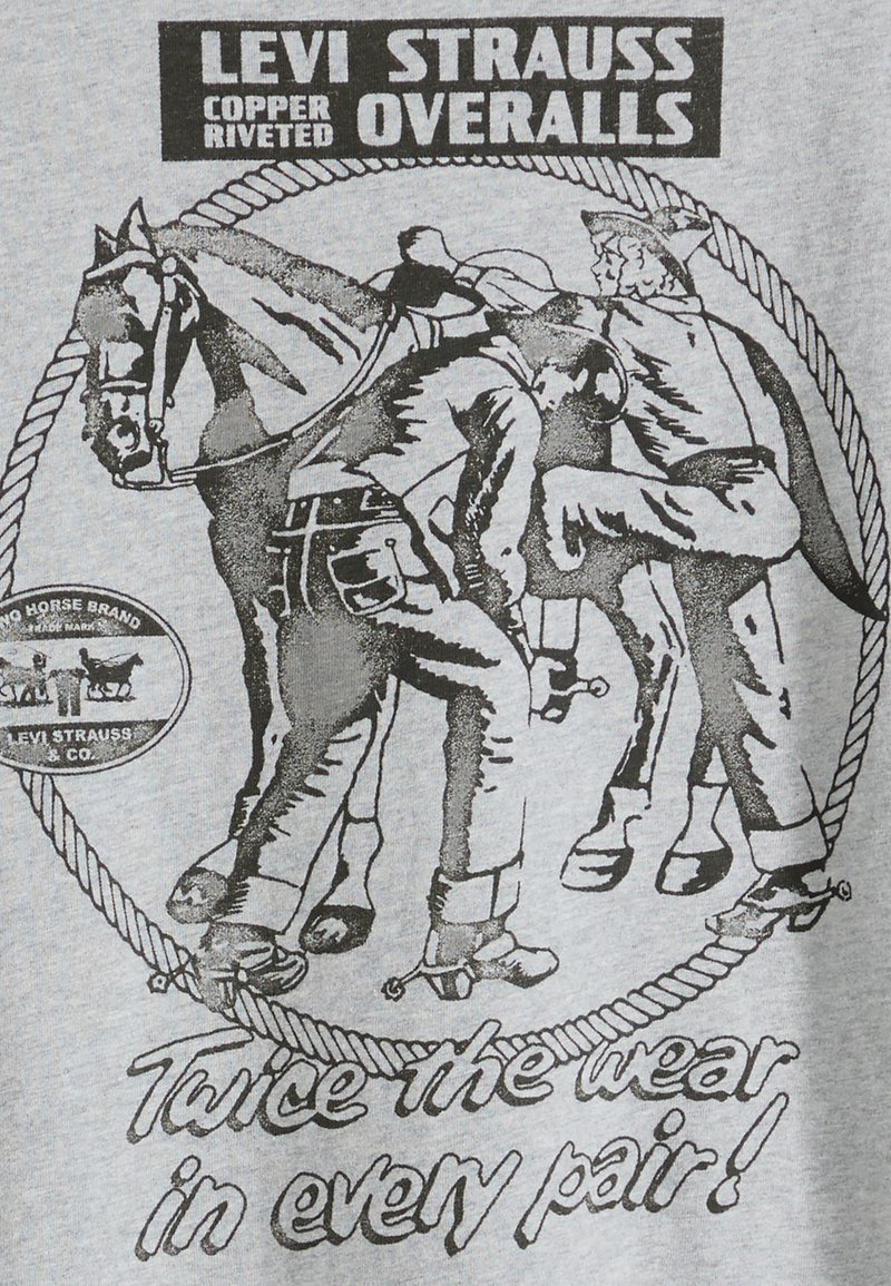 Le T-shirt graphique Levi Strauss présente une illustration en noir et blanc de deux hommes et un cheval, avec un texte et un motif circulaire en corde sur un fond gris.