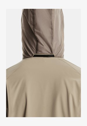 Beige takki, jossa on huppu, nähtynä takaa. Takissa näkyy kankaan texture ja ompeluyksityiskohdat kauluksen ja hupun ympärillä.