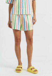 Shorts en coton rayés avec des rayures verticales multicolores dans les tons rose, bleu, vert et jaune, dotés d'un petit motif brodé sur le côté.