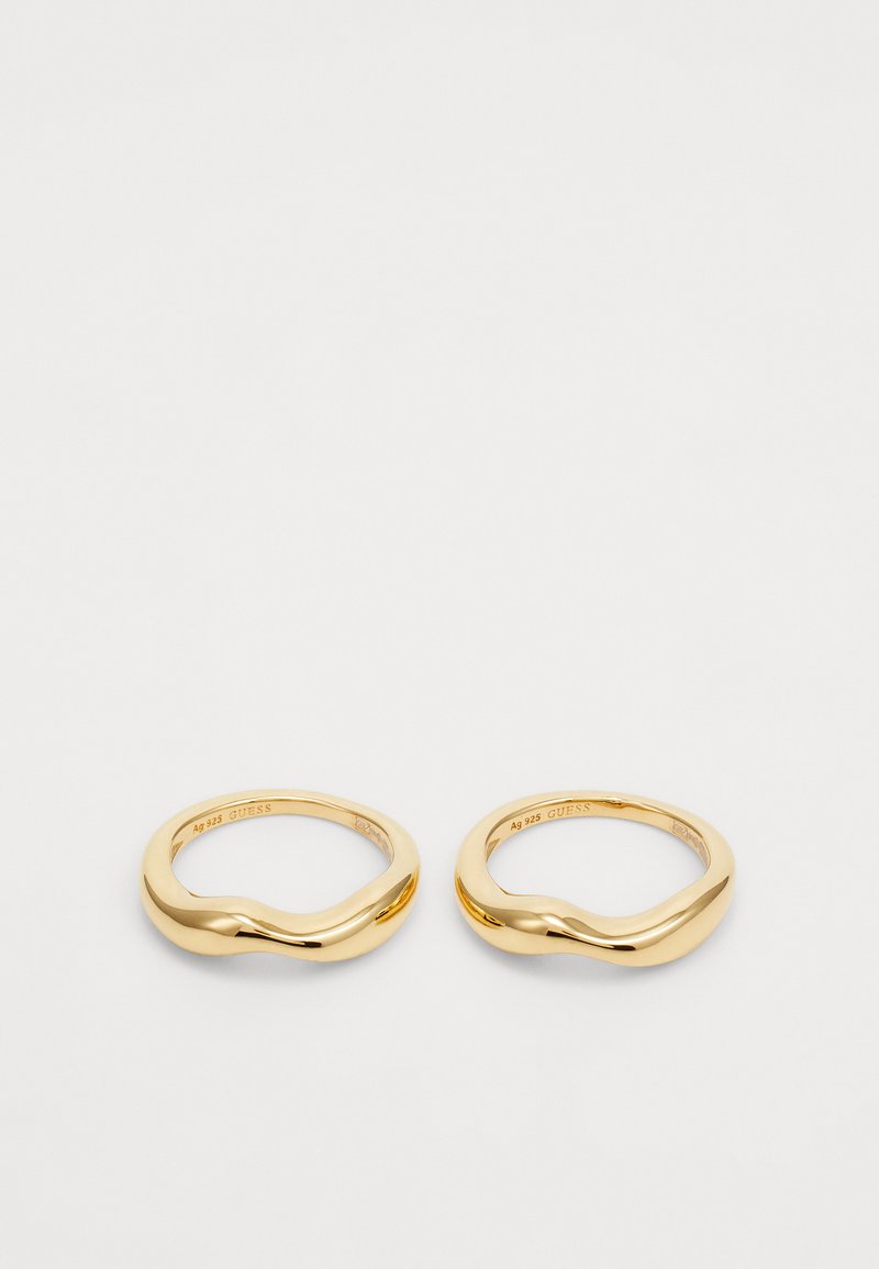 Gold-tone metal rings with a smooth, wavy design. Featuring a polished finish, they are flat on the inside and rounded on the outside.