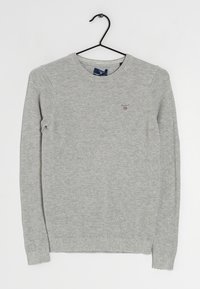 Suéter gris de punto con cuello redondo, puños y dobladillo acanalados, que presenta un pequeño logo en el pecho y un patrón texturizado en toda la prenda.