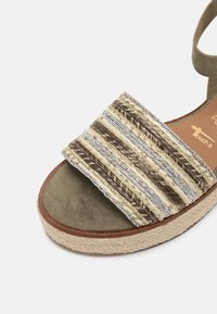 Sandale espadrille tissée avec une tige texturée en crème, marron et argent, dotée d'une semelle intérieure en daim et d'une semelle intermédiaire en jute tressé.