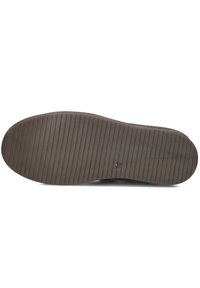 Rubberen schoenzool met een gestructureerd oppervlak, voorzien van horizontale groeven voor grip. De buitenrand is afgerond met een gladde afwerking.