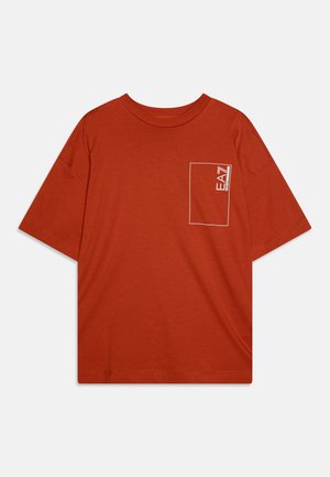 Camiseta naranja con cuello redondo, mangas cortas y un contorno de bolsillo blanco que presenta un pequeño logotipo en la esquina superior izquierda.