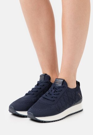 Baskets en maille bleu marine avec une tige texturée, une semelle intermédiaire blanche et une semelle extérieure en caoutchouc noir. Présentent un design à lacets et un accent de marque sur le talon.