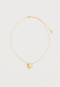 Κολιέ σε χρυσό τόνο με μενταγιόν σε σχήμα καρδιάς, διακοσμημένο με ένα μικρό κρύσταλλο και χαραγμένη επωνυμία, προσαρτημένο σε μια λεπτή αλυσίδα.