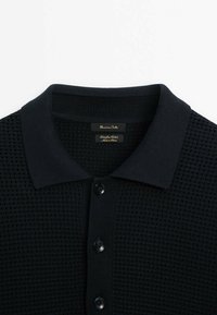 Polo noir en maille texturée avec col court et trois boutons noirs, étiquette Massimo Dutti, en coton.