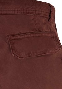 Bordeauxfarbene Baumwollhose mit einer aufgesetzten Tasche, ausgestattet mit einem strukturierten Stoff und einer sauberen Naht entlang der Kanten.