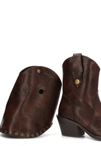 Botas de vaquero de cuero marrón con punta afilada y tacón en forma de bloque. Presentan detalles en latón y un polainas de cuero desmontable a juego con remaches.
