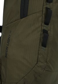 Κοντινό πλάνο υφάσματος σακιδίου πλάτης σε ελιά πράσινο με μαύρο φερμουάρ και ραμμένες θηλιές, με ετικέτα «NEON LIGHT 12» σε υφή επιφάνειας.