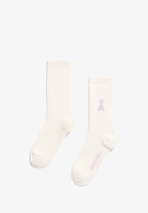 Chaussettes blanches côtelées avec un logo lilas sur le côté. Le matériau semble doux avec une texture lisse et une longueur de mi-mollet standard.