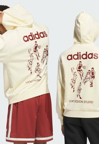 Cream hoodie with red graphics depicting basketball players; features a drawstring hood and ribbed cuffs. “adidas” text prominently displayed.