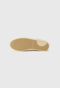 Semelle de chaussure en caoutchouc avec un motif texturé en grille. La couleur est beige avec un bord légèrement surélevé, portant l'inscription "MARQUE POMPEII" près du talon.