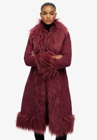 Bordeaux faux fur-gevoerd jasje met lange mouwen, een middellange snit en een gestructureerde kraag en manchetten. Heeft een zachte, pluizige uitstraling.