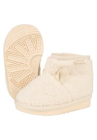 Cremfarbene Fellboots mit einer weichen Textur, im Slip-On-Design, und einer Gummisohle mit einem Sonnenstrahlenmuster. Auffällige seitliche Ventilationsdetails.