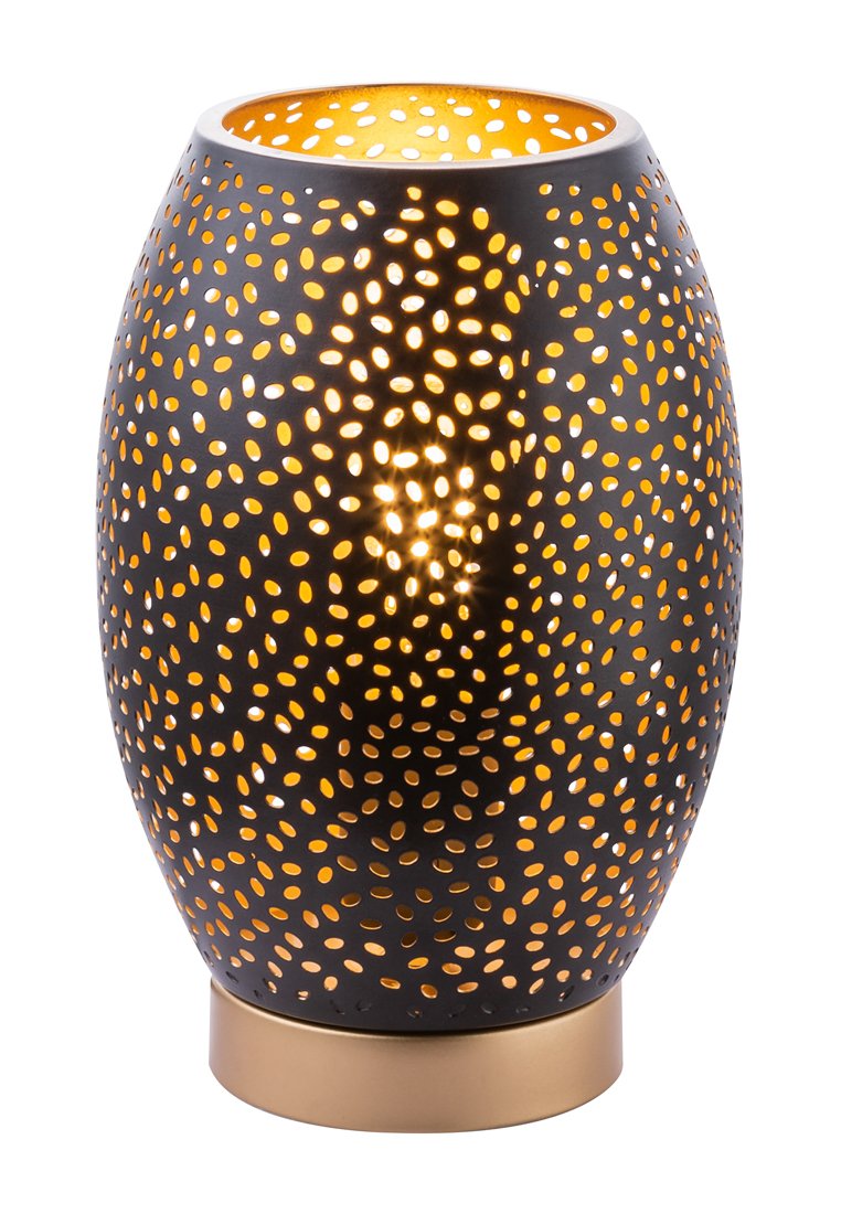 Lampe noire en métal avec une forme ovale, ornée de motifs découpés complexes. Émet une lueur chaleureuse, accentuée par une base de couleur dorée.